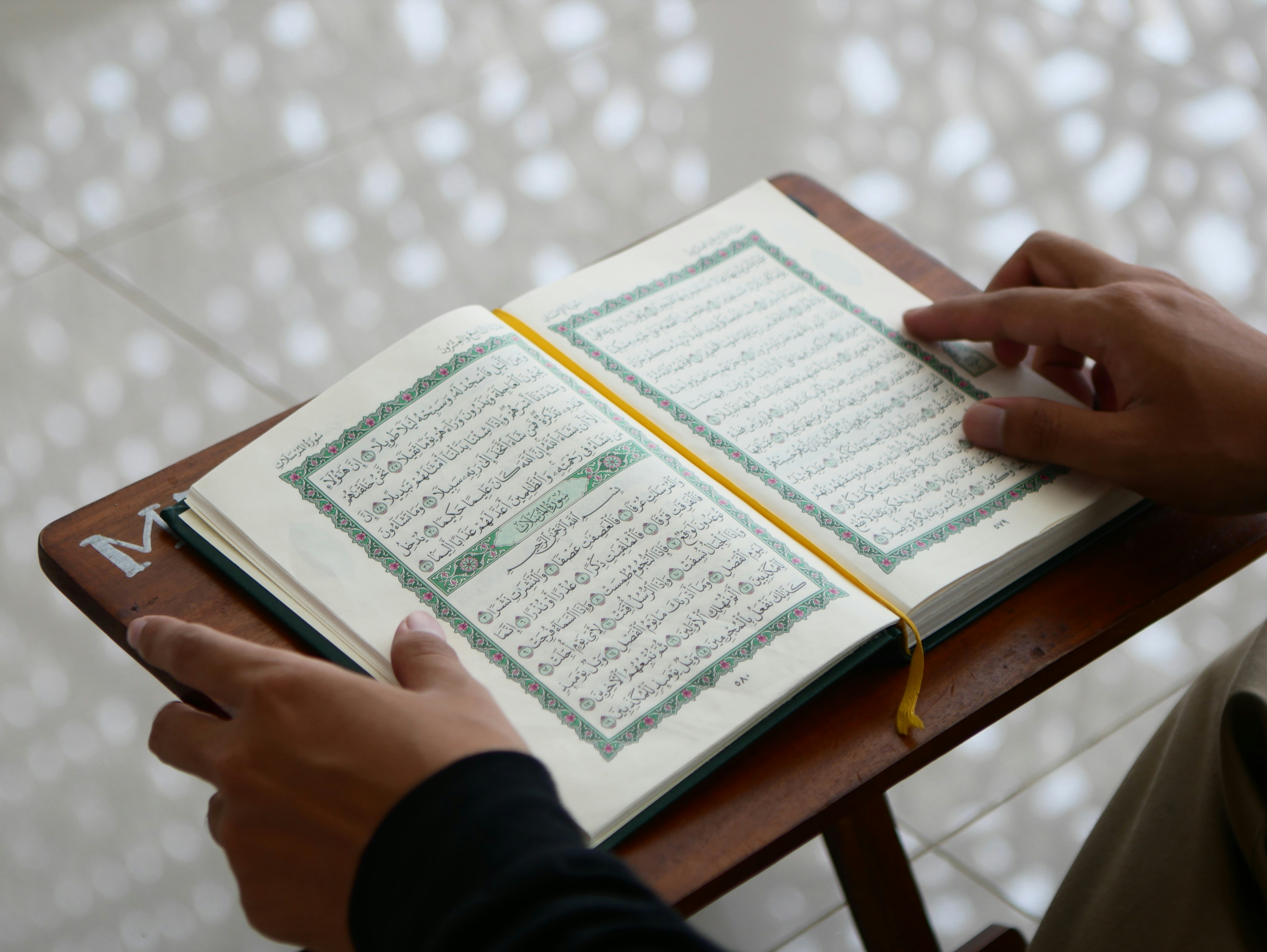 A student reading from an open Qur'an